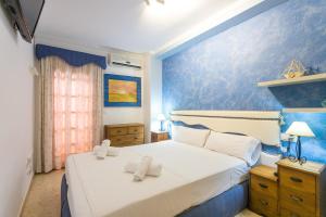 a bedroom with a white bed with towels on it at ApartUP Saplaya Harbour in Alboraya