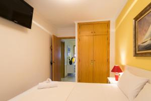 a bedroom with a bed and a tv on the wall at ApartUP Saplaya Harbour in Alboraya