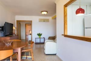 a living room with a table and a couch at ApartUP Saplaya Harbour in Alboraya