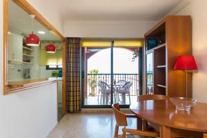 a kitchen and dining room with a table and a balcony at ApartUP Saplaya Harbour in Alboraya