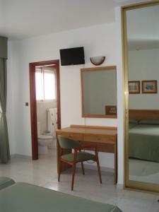 a bedroom with a desk and a mirror and a bed at Hotel Paraimo in A Lanzada