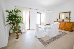 a white dining room with a table and a potted plant at Luxury penthouse Alena in Utjeha