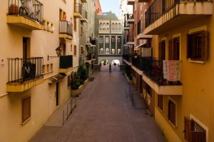 an empty alley between buildings in a city at ApartUP Saplaya Harbour in Alboraya