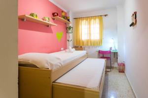 a bedroom with a bed and a pink wall at ApartUP Saplaya Harbour in Alboraya