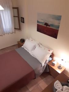 ピルガディキアにあるCute apartments with romantic viewのベッドルーム1室(ベッド1台付)が備わります。壁には絵画が飾られています。
