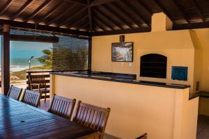 a restaurant with a bar and a table and chairs at Casa da Estrela in Barra do Cunhau