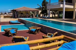 a swimming pool with lounge chairs next to a building at Casa da Estrela in Barra do Cunhau