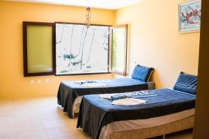 two beds in a room with a window at Casa da Estrela in Barra do Cunhau +24 photos
