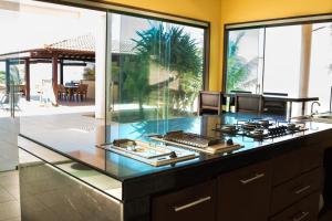 a kitchen with a stove top on a counter at Casa da Estrela in Barra do Cunhau
