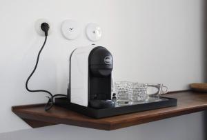 a black coffee machine sitting on a wooden shelf at Agave Room Rental in Riomaggiore