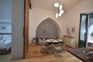ein Wohnzimmer mit einem Tisch und einem Bett in der Unterkunft La dimora del barone in Salerno