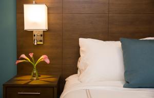 a vase with a flower on a night stand next to a bed at Staybridge Suites Seattle - South Lake Union, an IHG Hotel in Seattle
