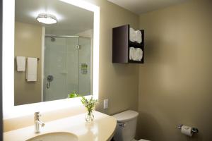 a bathroom with a toilet, sink, and mirror at Staybridge Suites Seattle - South Lake Union, an IHG Hotel in Seattle