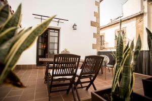 two chairs and a table on a patio with plants at MD Casa Palacio Muñoz Chaves Siglo XVIII in Cáceres