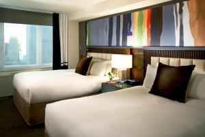 a hotel room with two beds and a large window at The Fifty Sonesta Hotel New York in New York