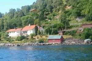 a group of houses on the shore of the water at Skogstad Holiday Home in Selje