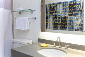 a bathroom with a sink and a toilet and a mirror at The Fifty Sonesta Hotel New York in New York +23 photos