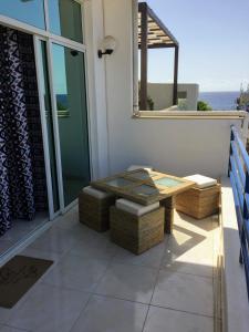 a patio with a table and chairs on a balcony at Casa Namaste Bed & Breakfast/Appartement in Praia