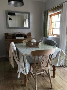 una sala da pranzo con tavolo, sedie e specchio di Stapehill Lodge B&B a Hampreston
