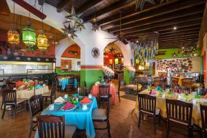 ein Restaurant mit Tischen und Stühlen in einem Raum in der Unterkunft Marina Fiesta Resort & Spa, A La Carte All Inclusive Optional in Cabo San Lucas