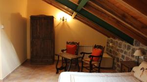a bedroom with two chairs and a table and a bed at Casa Rural El Pinar in Acebedo