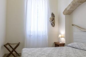 a bedroom with a bed and a large window at CASA MELIO' in Polignano a Mare