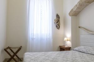sypialnia z łóżkiem i dużym oknem w obiekcie CASA MELIO' w mieście Polignano a Mare
