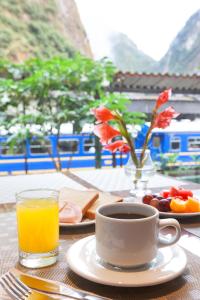 
a table with a cup of coffee and a plate of food at Inti Punku Machupicchu Hotel & Suites in Machu Picchu

