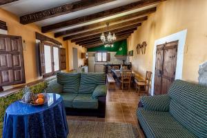 イェクラにあるCasa Rural El Llano Quintanillaのリビングルーム(緑のソファ、テーブル付)