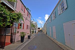 an empty alley with pink and blue buildings at Historic Apartment in the Heart of Christiansted in Christiansted