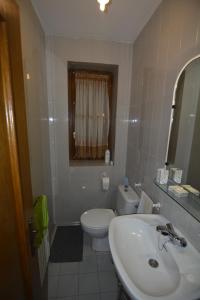 y baño con lavabo, aseo y espejo. en Casa Rural Teodoro Barrio, en Aribe