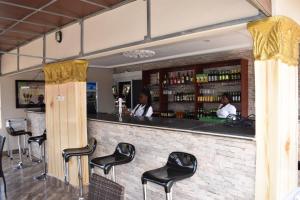 bar z czarnymi stołkami przed ladą w obiekcie Cascade Hotel w mieście Lapaz
