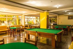 a pool table in a room with tables and chairs at Candeias Hotel Gold Fish in Corumbá