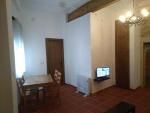 a dining room with a table and a tv on a wall at Casa Rural La Tia Rosa in Chulilla