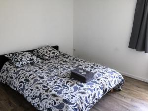 - une chambre avec un lit et une couette noire et blanche dans l'établissement Maison entière au pied des vignes, à Lussac