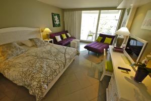um quarto com uma cama e uma sala de estar em Résidence de La Vieille Tour em Le Gosier