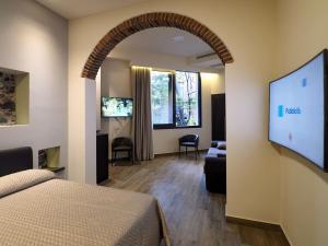 una camera con letto e TV a schermo piatto di Relais Anfitheatro a Catania