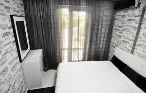 a bedroom with a white bed and a window at Hotel Chanel Apartments in Tbilisi City