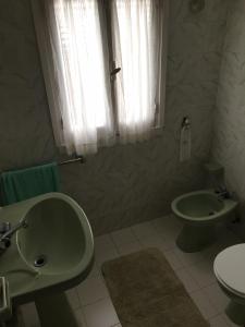 a bathroom with a sink and a toilet and a window at Vivienda vacacional casa pereira luarca in Cabornas