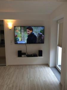 einen Flachbild-TV an der Wand im Wohnzimmer in der Unterkunft La Vie in Kappeln