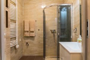 La salle de bains est pourvue d'une douche et d'un lavabo. dans l'établissement Apartamenty Koba, à Ustroń