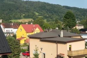 une maison jaune avec un toit noir dans une ville dans l'établissement Apartamenty Koba, à Ustroń