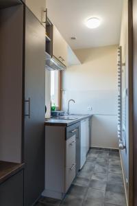 a small kitchen with white cabinets and a tile floor at Apartamenty Koba in Ustroń
