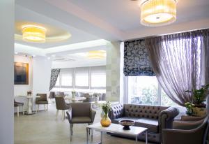 a waiting room with a couch and chairs and tables at Hotel Rodon in Paralia Katerinis