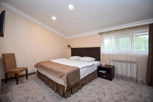 1 dormitorio con 1 cama, 1 silla y 1 ventana en Laguna Hotel, en Vanadzor