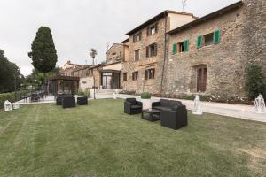 a garden with black chairs in front of a building at Hotel Le Macine in Montaione