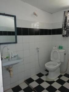 a bathroom with a toilet and a sink and a mirror at Sunny House Paje II in Paje