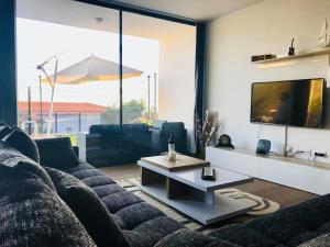 ein Wohnzimmer mit einem Sofa und einem TV in der Unterkunft migs'place in Arco da Calheta