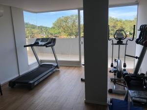 a gym with a treadmill and a large window at Serra Madre in Rio Quente