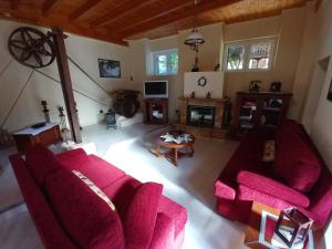 a living room with a red couch and a table at Old Olive House in Kouroukláta